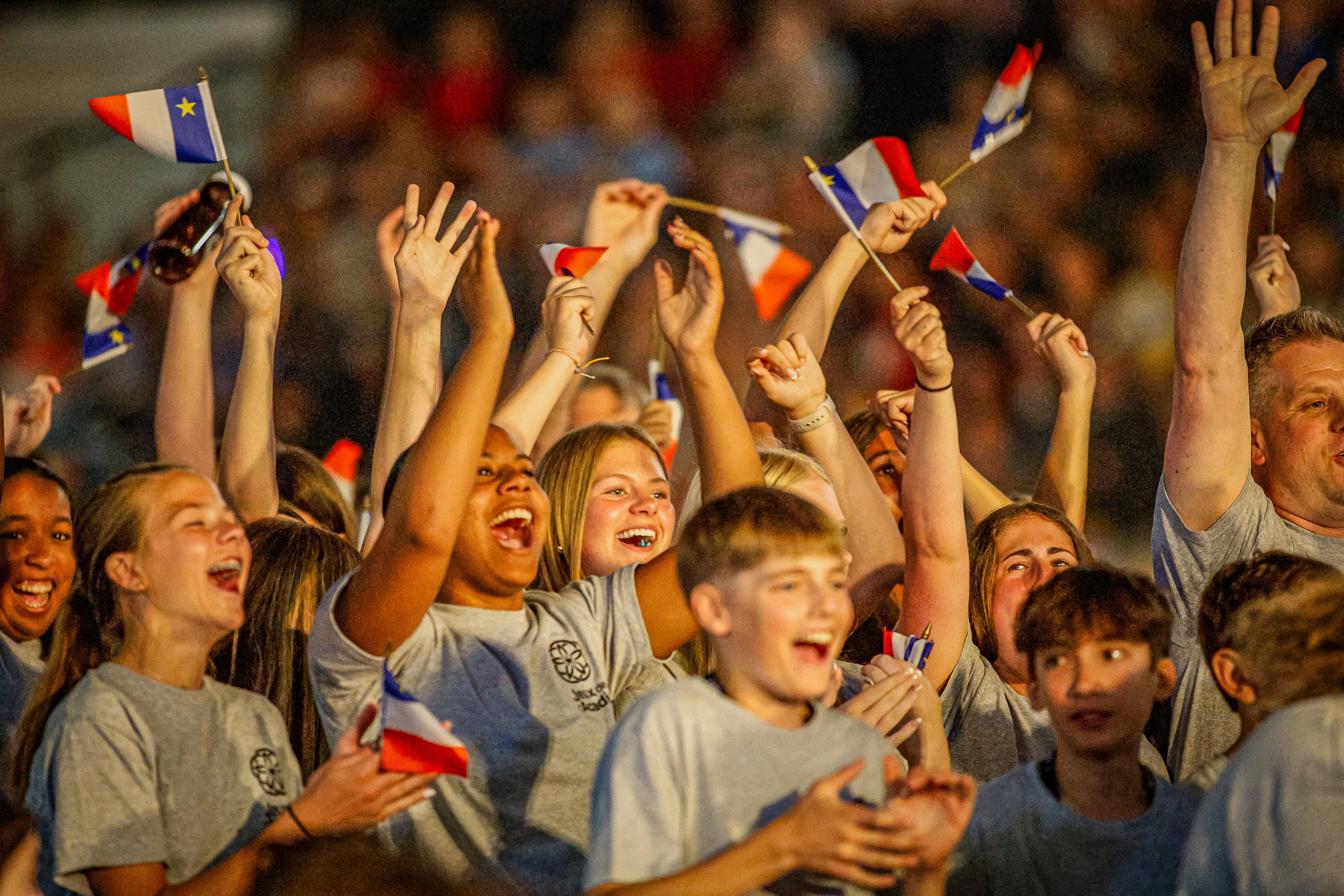 Crowd of youths waving Acadian flags