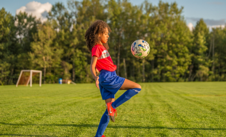 Fille qui joue au soccer au parc Dover